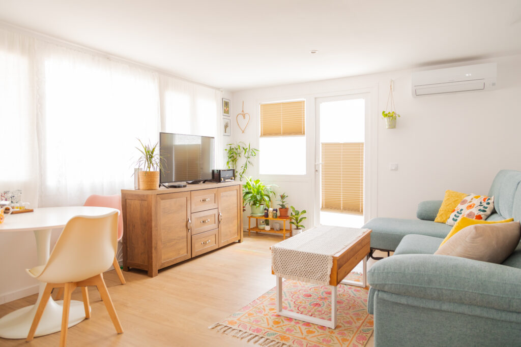 salón luminoso con tele, sofá y mesa de comedor